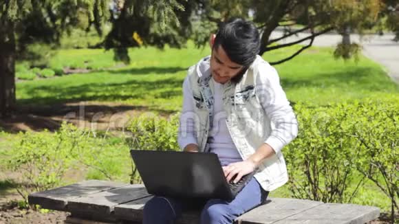 有笔记本电脑的亚洲人在公园打电话视频的预览图