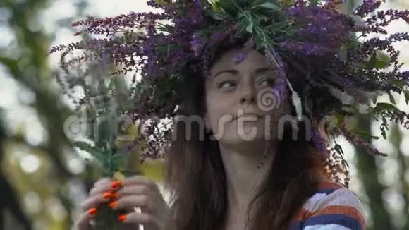 特写镜头美丽的女孩矢车菊的头上长着一朵花手里拿着几朵花看着它视频的预览图