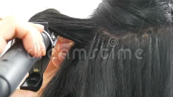 长长的美丽的黑发卷发设计师卷发头发造型和卷发头部的扩张囊视频的预览图