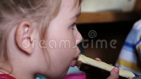 小女孩正在吃一个加黄油的三明治还特写镜头视频的预览图