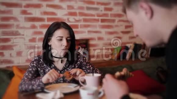 咖啡馆里的男人和女人喝咖啡和羊角面包视频的预览图