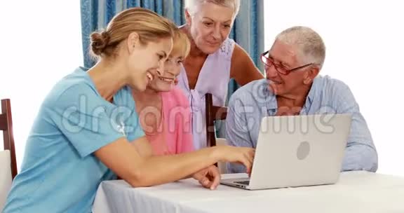 女性志愿者和使用笔记本电脑的老年公民视频的预览图