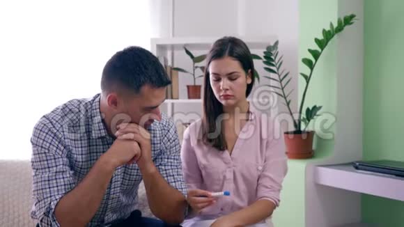 怀孕测试呈阳性的愤怒的家庭夫妇了解到计划外怀孕并被光明的结果所困扰视频的预览图