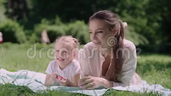 在公园草地上玩耍的母子视频的预览图