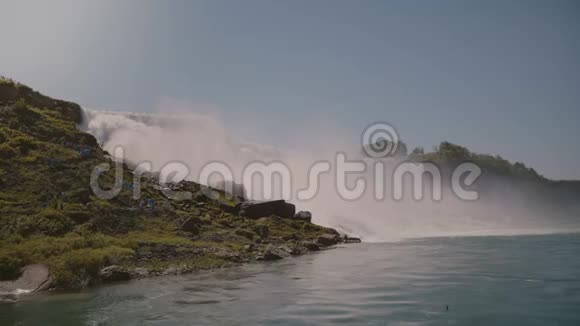 在晴朗的日子里游客们穿着雨衣在美丽的尼亚加拉瀑布观看史诗般的水墙视频的预览图