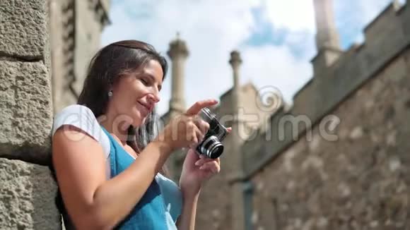 微笑女性专业摄影师用相机拍摄中世纪城堡视频的预览图