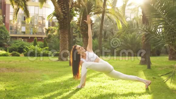 健康的生活锻炼理念女性在瑜伽公园户外做延伸三角姿势视频的预览图
