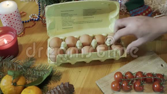 圣诞厨房蜡烛和树枝附近的新鲜鸡蛋烹饪用的材料和工具视频的预览图