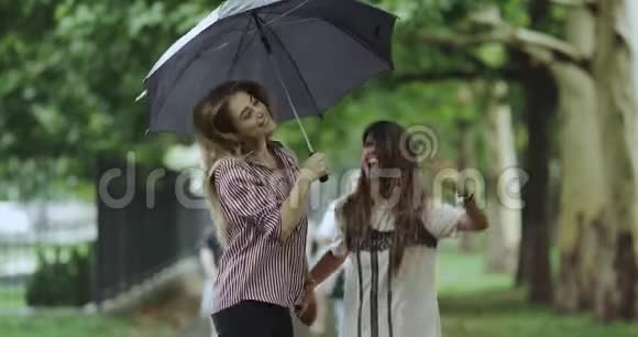下雨天两个漂亮的女士在公园里跳4k缓慢的动作视频的预览图