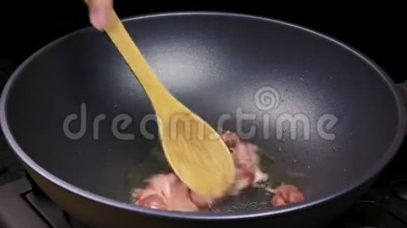 切好的鸡片用炒锅里的生物油炒成烹饪过程的一部分在自制食谱上关闭视频的预览图