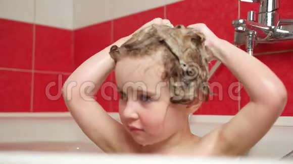 可爱的小女孩用香波洗头发视频的预览图
