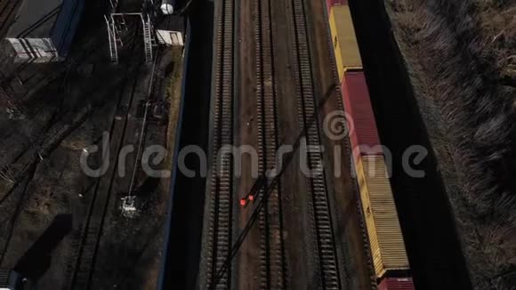 两名铁路工人在常备货运列车旁边的铁轨上工人团队保证铁路服务空中景观视频的预览图