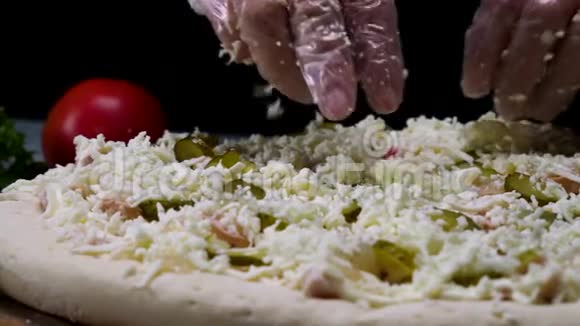 接近制作比萨饼的过程由厨师手隔离在黑色背景框架把奶酪层对齐视频的预览图