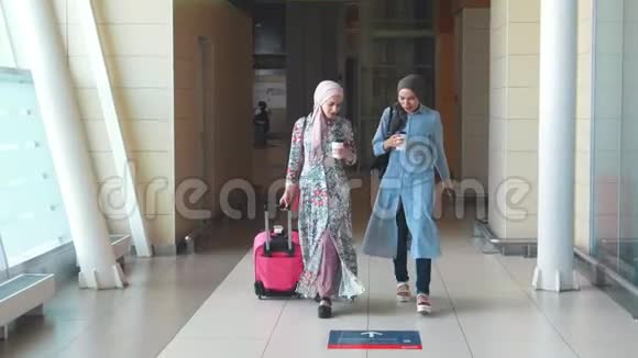 两个穆斯林女孩走路说话喝咖啡视频的预览图