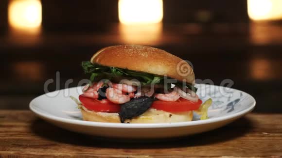将美味的汉堡包与西红柿青菜和虾合在一起放在白色盘子上在木板上旋转视频的预览图