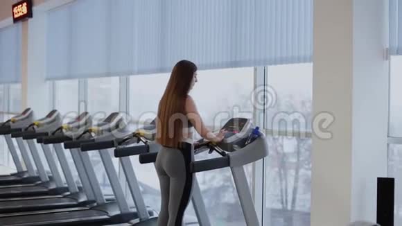 非常漂亮的女人准备在健身房的跑步机上跑步视频的预览图