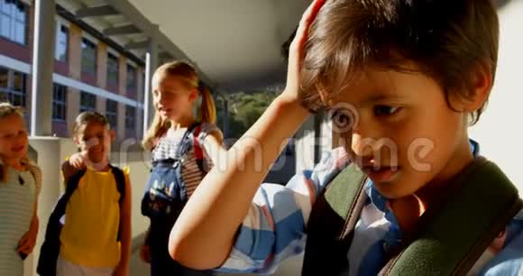 小学生们在小学走廊里欺负一个悲伤的男孩视频的预览图