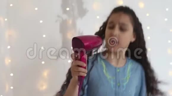 年轻女孩在吹风机里唱歌跳舞时心情很好高清家庭风格特写视频的预览图