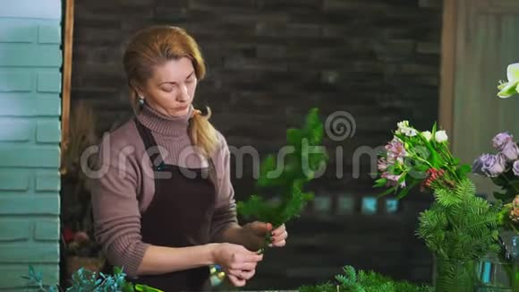 女花匠清洗杉枝从松针准备花束视频的预览图