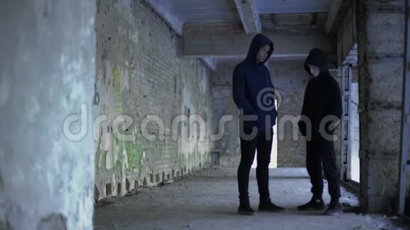 穿着连帽衫的男孩在破楼里说话青少年团伙年轻罪犯视频的预览图
