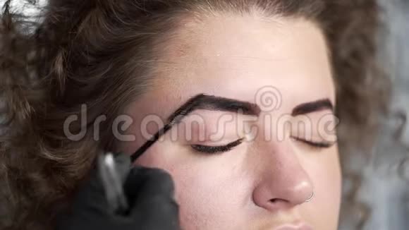 女人着色后用眉刷把眉毛梳好在美的时候给卷曲的美女修眉视频的预览图