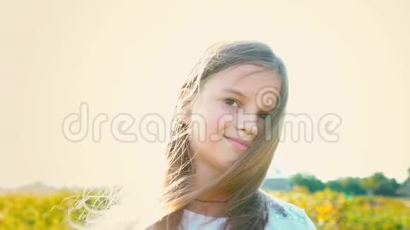 有魅力的小女孩的肖像有一双棕色的大眼睛在大自然的背景下有着发育的头发女孩的微笑和视频的预览图
