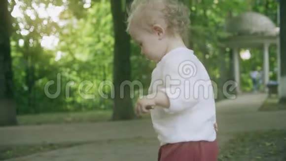 夏天一个金发小女孩在公园散步视频的预览图