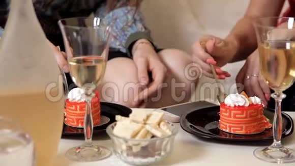 两个年轻女孩花时间在家里吃橘子蛋糕和白巧克力交流友谊欢笑晚上视频的预览图