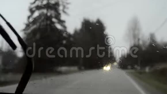 雨中驾驶失去焦点背景和大灯沉闷的一天手持视频的预览图