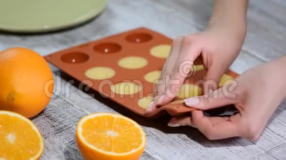 手拿橙色填充从一个灵活的硅胶模具视频的预览图