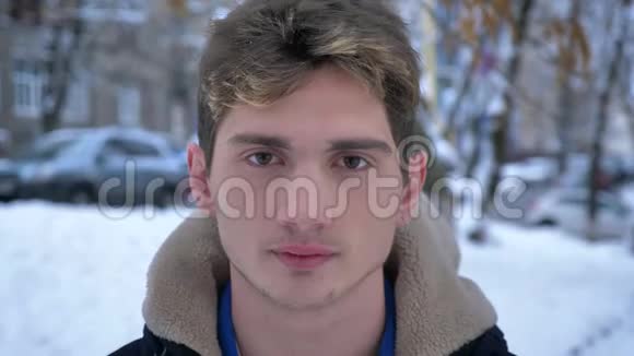 年轻有魅力的白种人男性的特写镜头直勾勾地看着站在街道室外的摄像机视频的预览图