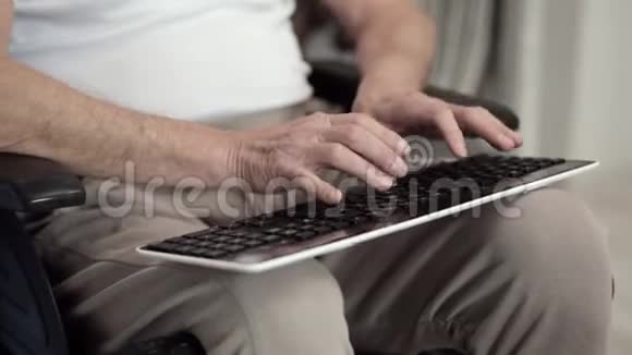 一位坐轮椅的成年男性在打字时拿着键盘视频的预览图
