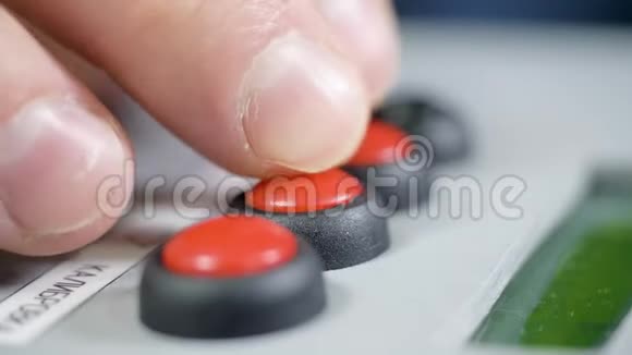 特写手指按控制面板上的红色和黑色按钮视频的预览图