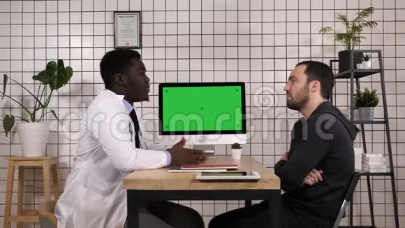 医生在电脑上给病人看病历他指着屏幕白色显示器视频的预览图