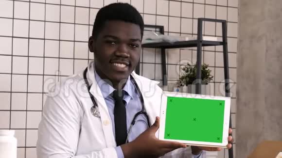 微笑的医生在平板电脑上展示产品白色显示器视频的预览图