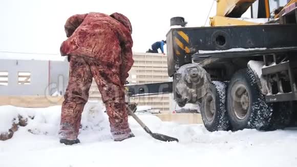 穿着防护服的人从小路上铲雪视频的预览图