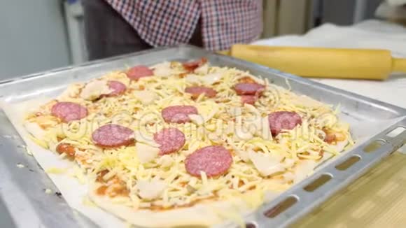 男人在厨房里做意大利腊肠披萨双手特写视频的预览图