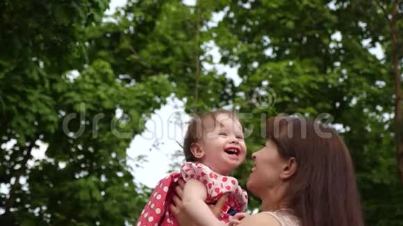 宝贝嘲笑爱妈妈的手宝贝和妈妈笑了一起在公园散步慢动作视频的预览图