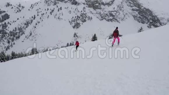 在滑雪者附近活动他们在困难的山坡上滑雪视频的预览图