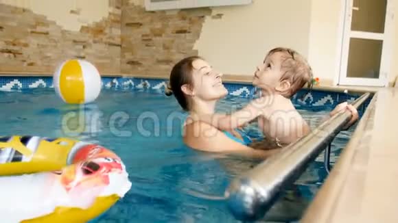 幼儿男孩与母亲在游泳池游泳和玩充气玩具的4k视频视频的预览图