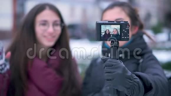 两位深黑肤色的女孩朋友和博客作者在冬季旅行时用相机录制视频视频的预览图
