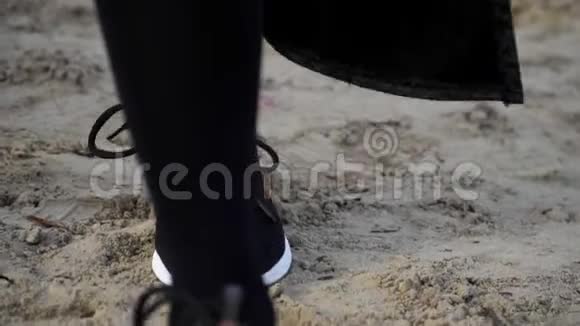 在沙滩上行走的时尚运动鞋中收拢双腿慢动作稳定射击概念鞋视频的预览图