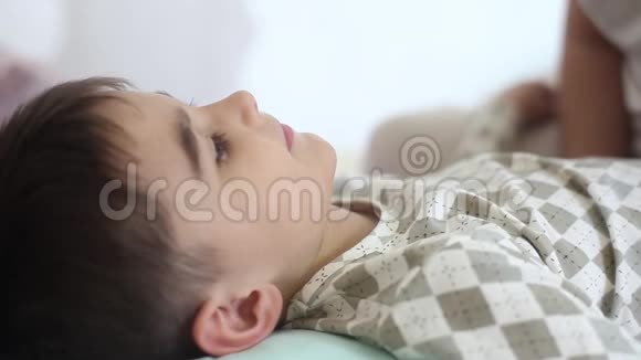 一个漂亮的女孩在他睡觉的时候亲吻一个留着短发的小孩子慢动作视频的预览图