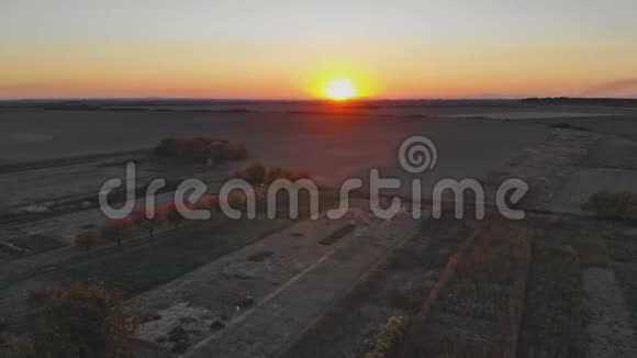 日落时分在乡村的田野下在田园诗般的乡村风景中在日落时分无人机飞过视频的预览图