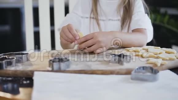 穿着白色连衣裙留着长发的小女孩在准备烤饼干时会从生面团里做胡子儿童视频的预览图