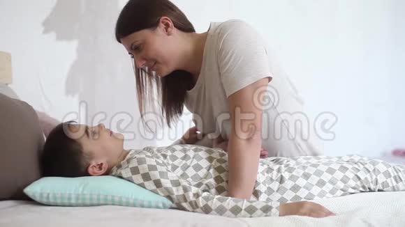 妈妈吻她心爱的儿子而他躺在床上拥抱她视频的预览图