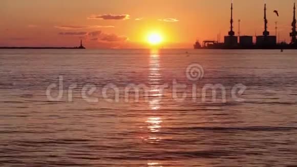 海港五彩缤纷的日落背景中的太阳落在地平线上视频的预览图