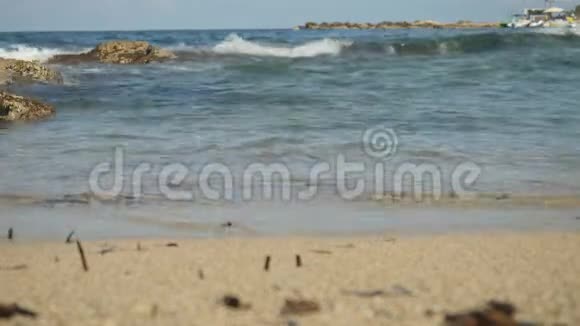 高潮与令人惊叹的蓝色涟漪的水溅在塞浦路斯沙滩上小波浪产生泡沫和气泡视频的预览图