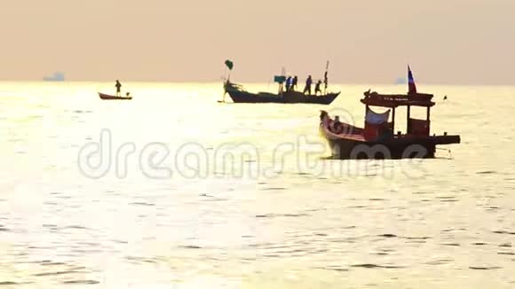 渔船在海水中漂浮在美丽的晚霞中视频的预览图