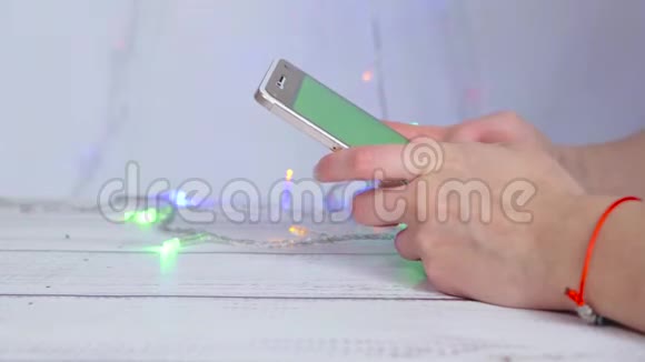 特写女性手拿着手机在触摸屏上打字这个女孩通过她在网上工作视频的预览图